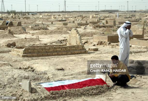 Relatives mourn before the grave of fourteen-year-old Sufian Daoud 18 September 2003 in Fallujah, 50 kilometers west of Baghdad. The Iraqi youth was...
