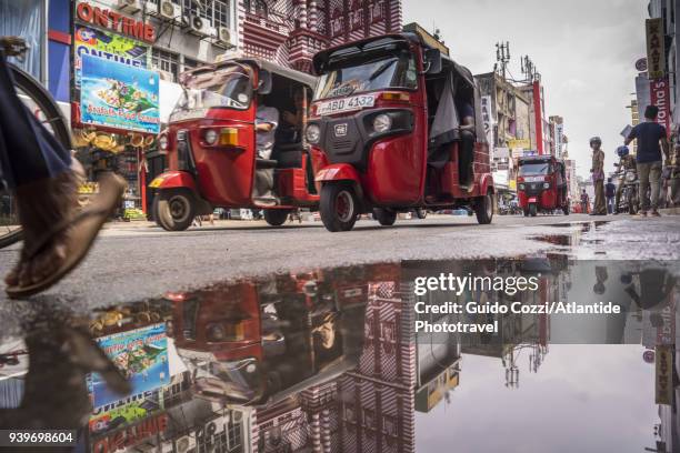 tuk-tuk in front of red masjid mosque, along main street, pettah bazar - colombo stock pictures, royalty-free photos & images