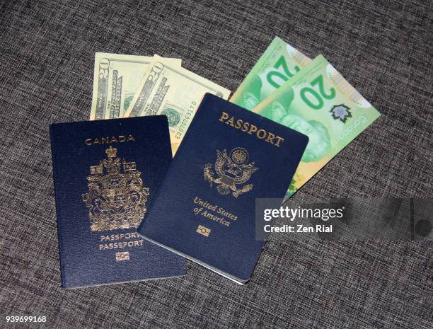 high angle view of canadian and american (usa) passports and twenty dollar bills - twenty canadian dollar note stock pictures, royalty-free photos & images