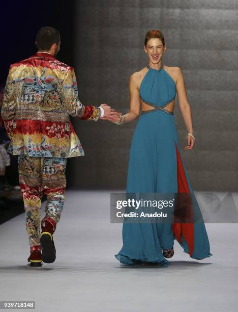 Models shake hands while presenting a creation of designer Niyazi Erdogan during the Mercedes-Benz Fashion Week/Fall Season 2018 at the Zorlu...