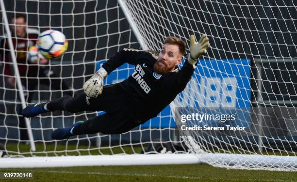 Goalkeeper Rob Elliot dives in the air to save the ball during the Newcastle United Training session at the Newcastle United Training Centre on March...