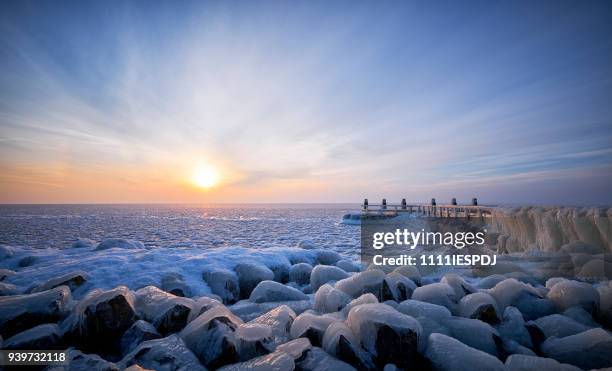 frozen lake with an icy jetty during sunrise - 1111iespdj stock pictures, royalty-free photos & images