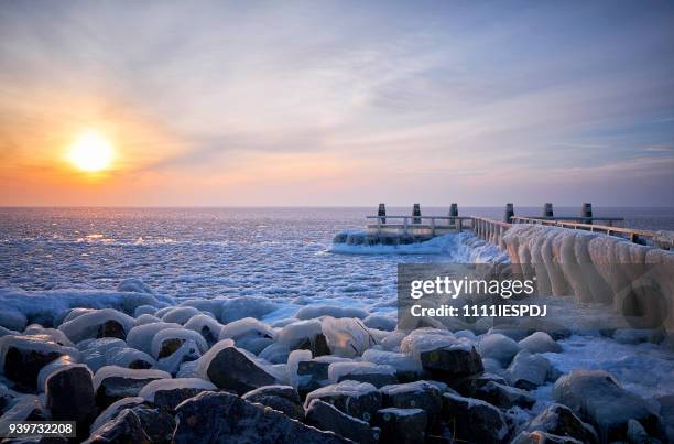 frozen lake with an icy jetty during sunrise - 1111iespdj stock pictures, royalty-free photos & images