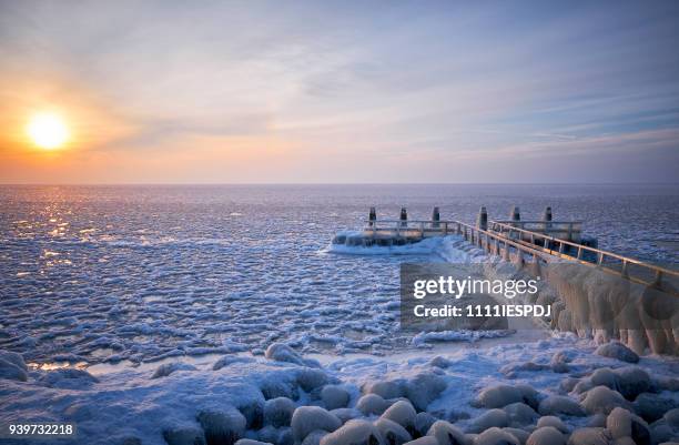 frozen lake with an icy jetty during sunrise - 1111iespdj stock pictures, royalty-free photos & images