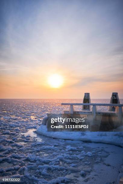 zugefrorenen see mit einem eisigen steg bei sonnenaufgang - 1111iespdj stock-fotos und bilder