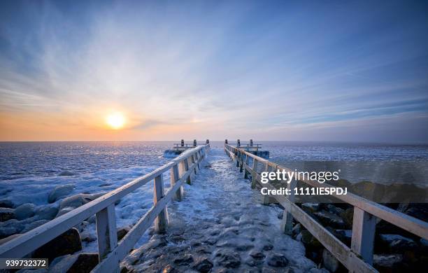 frozen lake with an icy jetty during sunrise - 1111iespdj stock pictures, royalty-free photos & images