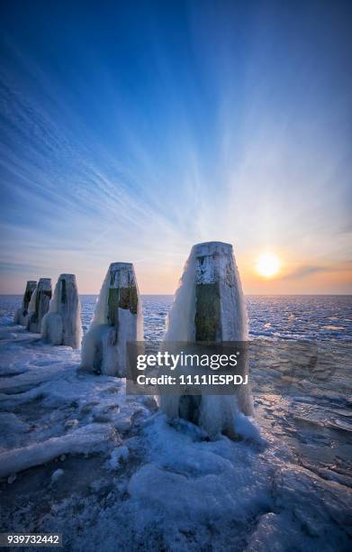 frozen lake with an icy poles during sunrise - 1111iespdj stock pictures, royalty-free photos & images