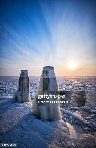 frozen lake with an icy poles during sunrise - 1111iespdj stock pictures, royalty-free photos & images