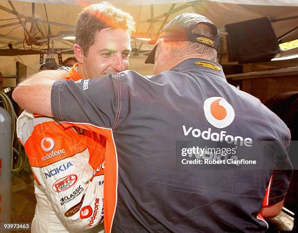 Jamie Whincup driver of the Team Vodafone Ford is congratulated by team principal Roland Dane after he won the championship during race 25 for the...