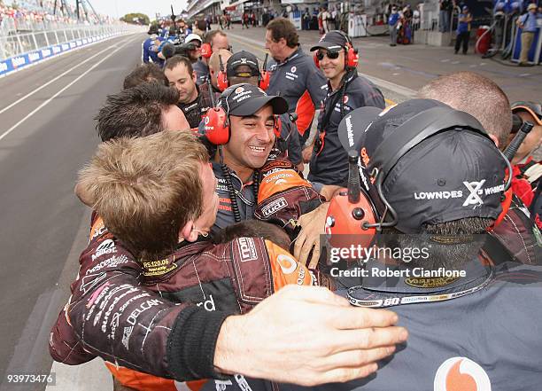 Team members of Team Vodafone celebrate after Jamie Whincup driving the Team Vodafone Ford won the championship during race 25 for the Sydney 500...