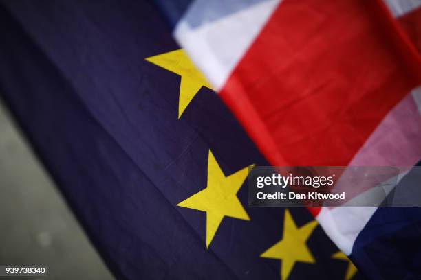 And Union flags sag in the rain as anti Brexit demonstrators continue their protest outside the Houses of Parliament on March 29, 2018 in London,...