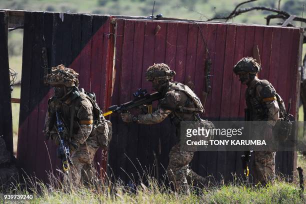 Soldiers take up position as they take part in a simulated military excercise of the British Army Training Unit in Kenya together with the Kenya...