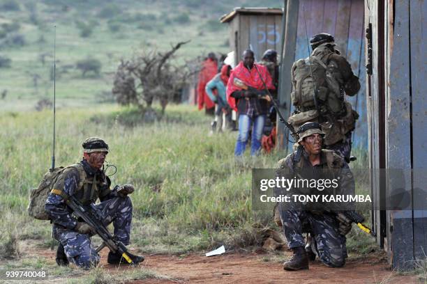 Soldiers defend position at a mock insurgent training camp during a simulated military excercise of the British Army Training Unit in Kenya together...