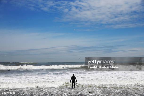 Surfer takes to the water in Winthrop, Mass., on March 28, 2018.