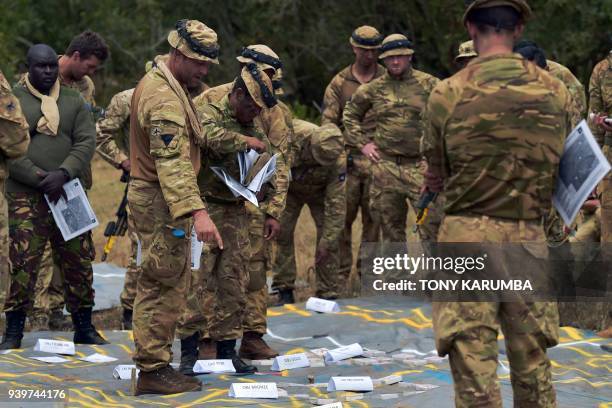 Soldiers study tactical positions during a simulated military excercise of the British Army Training Unit in Kenya together with the Kenya Defence...