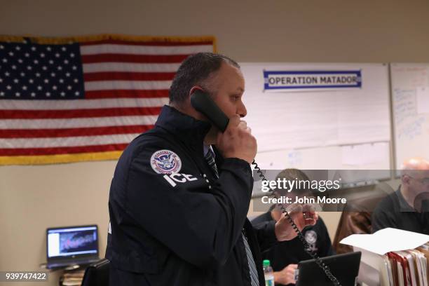 Homeland Security Investigations ICE agents work in a control center during an operation targeting suspected immigrant gang members in Central Islip,...