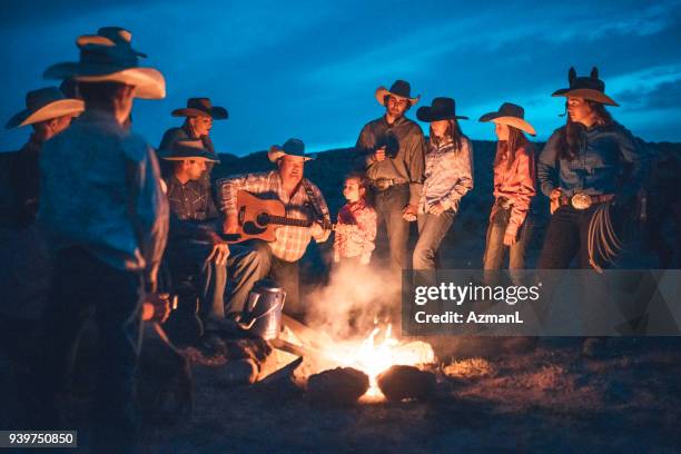 cowboys sitting around campfire - campfire storytelling stock pictures, royalty-free photos & images