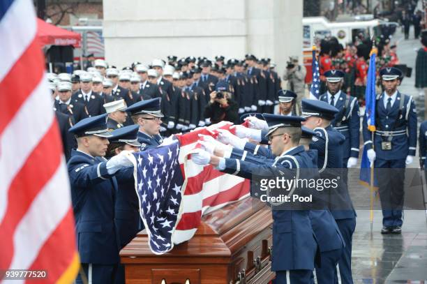 Honor guard fold the flag that was draped on the coffin of FDNY Fire Marshal Capt. Christopher "Tripp" Zanetis during his funeral in Washington...