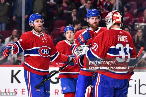 Jeff Petry and Karl Alzner of the Montreal Canadiens congratulate goaltender Carey Price for their victory against the Detroit Red Wings during the...