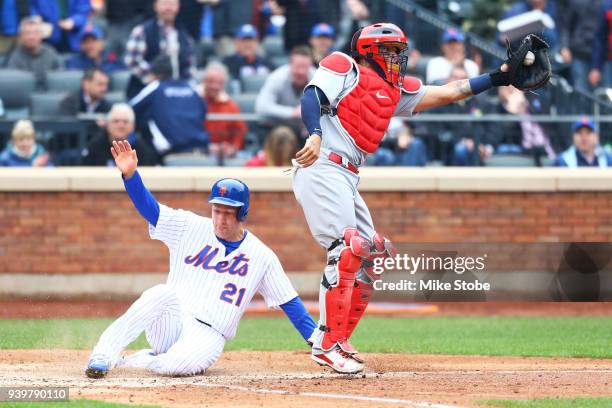 Todd Frazier of the New York Mets scores on Adrian Gonzalez RBI single in the fifth inning in front of Yadier Molina of the St. Louis Cardinals on...