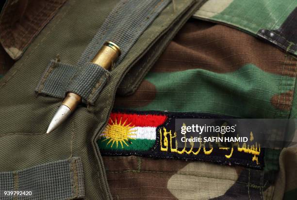 The badge of Syrian-Kurdish Peshmerga fighter and member of the Rojava Forces Defence Units is seen as he holds a position in the town of Faysh...