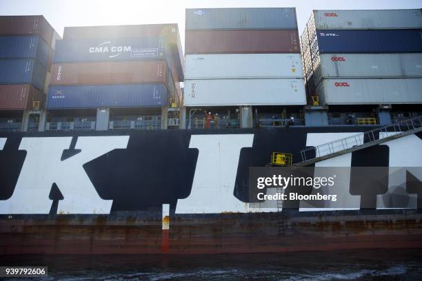 Crew members wave from the NYK Demeter container ship outside the Port of Los Angeles in Los Angeles, California, U.S., on Wednesday, March 28, 2018....