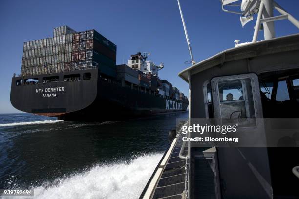 Boat pulls alongside the NYK Demeter container ship to transfer a port pilot outside the Port of Los Angeles in Los Angeles, California, U.S., on...