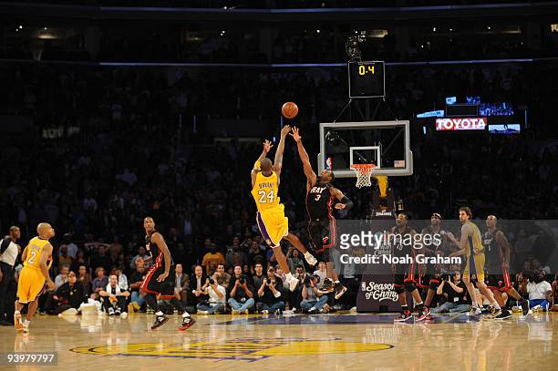 Kobe Bryant of the Los Angeles Lakers shoots over Dwyane Wade of the Miami Heat with .04 seconds remaining for the win at Staples Center on December...