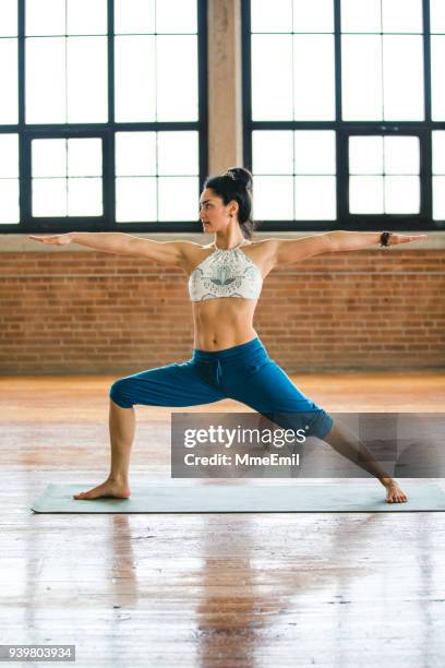 woman practicing yoga. warrior position. virabhadrasana ii - warrior position stock pictures, royalty-free photos & images