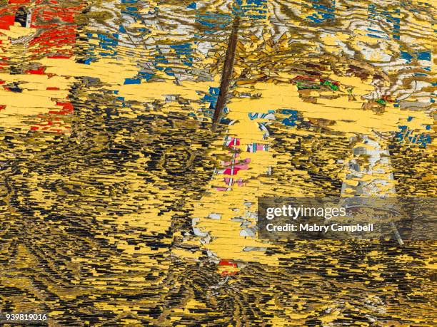 cracked and peeling yellow paint on sign on plywood - abiquiu foto e immagini stock