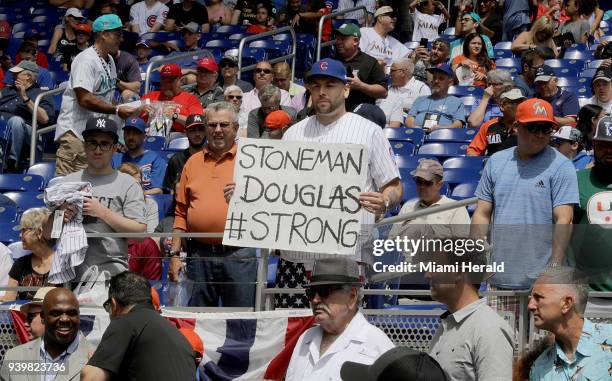 Chicago Cubs fan holds a banner supporting the Stoneman Douglas #Strong movement during the third inning against the Miami Marlins during 2018...