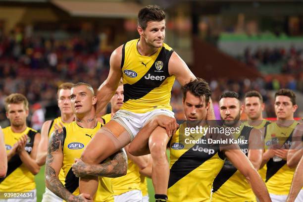 Trent Cotchin of the Tigers is chaired off the field by Dustin Martin of the Tigers and Alex Rance of the Tigers during the round two AFL match...