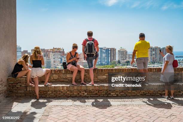 tourists look at view from the alcazaba of malaga andalusia spain - alcazaba of málaga stock pictures, royalty-free photos & images