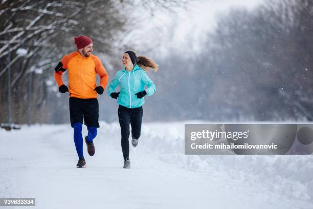runners on the snow - winter running stock pictures, royalty-free photos & images