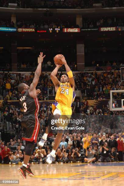 Kobe Bryant of the Los Angeles Lakers shoots a last-second three pointer against Dwyane Wade of the Miami Heat to win the game at Staples Center on...