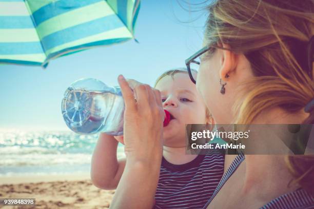 child drinking water on the beach - baby drinking water stock pictures, royalty-free photos & images