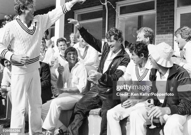 John Wright of New Zealand pours champagne over teammate Lance Cairns as the New Zealand team celebrate their first Test win over England at the end...