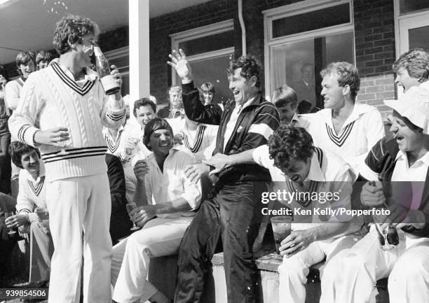 John Wright of New Zealand pours champagne over teammate Lance Cairns as the New Zealand team celebrate their first Test win over England at the end...