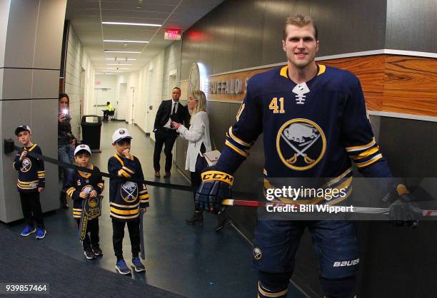 Justin Falk of the Buffalo Sabres smiles with fans as he prepares to take the ice before NHL game against the Detroit Red Wings on March 29, 2018 at...