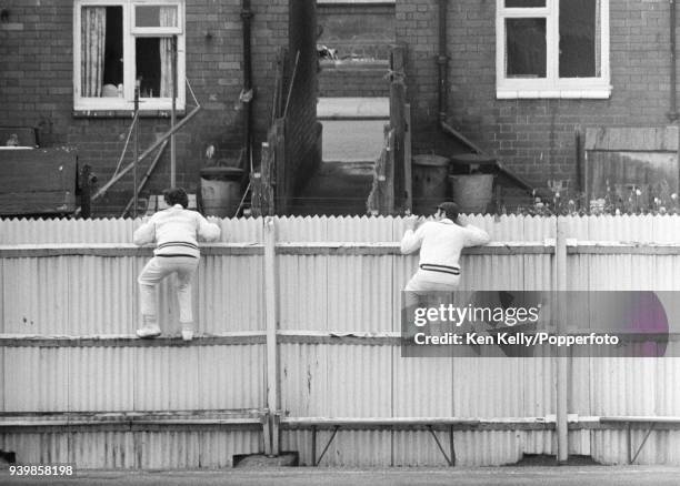 Two Warwickshire players climb the fence looking for the ball during the Benson and Hedges Cup match between Warwickshire and Leicestershire at...