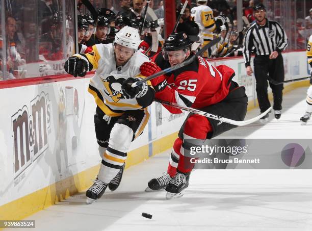Mirco Mueller of the New Jersey Devils steers Bryan Rust of the Pittsburgh Penguins towards the boards during the first period at the Prudential...