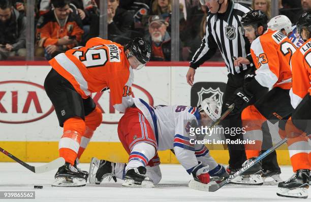 Nolan Patrick and Brandon Manning of the Philadelphia Flyers battle for the loose puck against David Desharnais of the New York Rangers on March 22,...