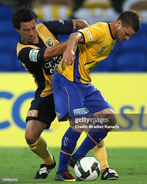 Jason Culina of United is pressured by John Hutchinson of the Mariners during the round 17 A-League match between Gold Coast United and Central Coast...