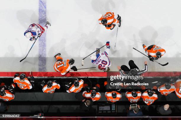 Scott Laughton, Matt Read and Jori Lehtera of the Philadelphia Flyers battle in front of thier bench against Chris Kreider and Jesper Fast of the New...