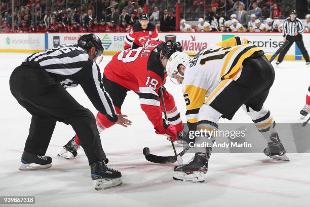 Travis Zajac of the New Jersey Devils faces off against Riley Sheahan of the Pittsburgh Penguins during the game at Prudential Center on March 29,...