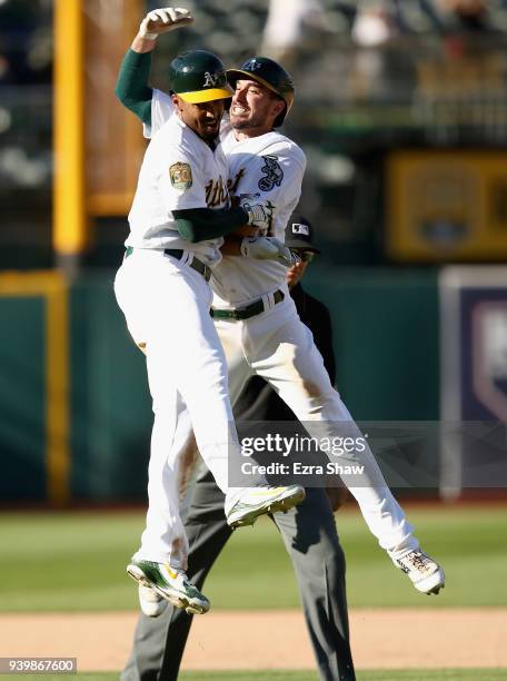 Matt Joyce of the Oakland Athletics celebrates with Marcus Semien of the Oakland Athletics after Semien hit the winning RBI single that scored Boog...