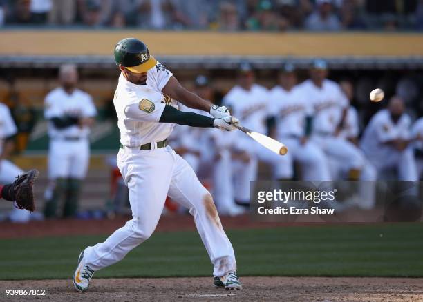Marcus Semien of the Oakland Athletics hits an RBI single that scored Boog Powell in the 11th inning to beat the Los Angeles Angels at Oakland...