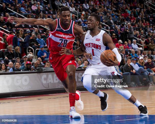 Reggie Jackson of the Detroit Pistons drives to the basket on Ian Mahinmi of the Washington Wizards during an NBA game at Little Caesars Arena on...