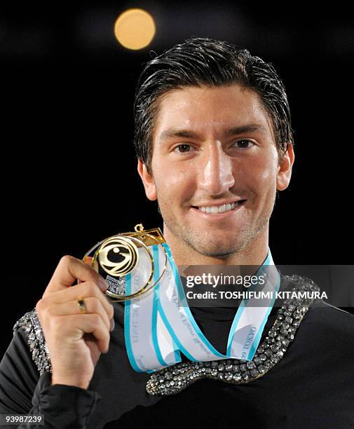 Men's singles winner Evan Lysacek of the US shows off his gold medal on the podium after the men's free skating singles competition of the figure...