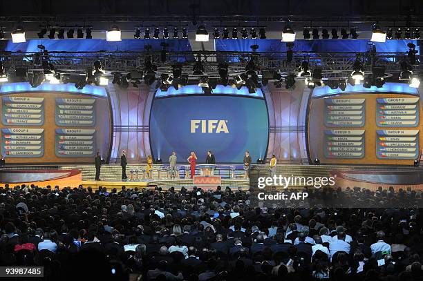 Secretary general Jerome Valcke flanked by South African actress Charlize Theron stand with the full 8 groups on the big screens after the World Cup...